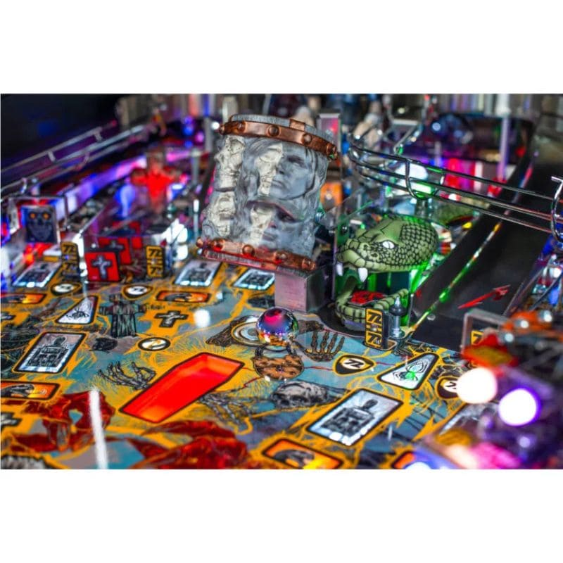 Close-up of a Metallica pinball machine Playfield with colorful artwork, snake and bright lights.
