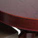 Close-up of a rockwell poker table oval poker table with dining top a chair partially visible.
