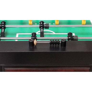 Close-up of a foosball table with green playing surface and metal rods.