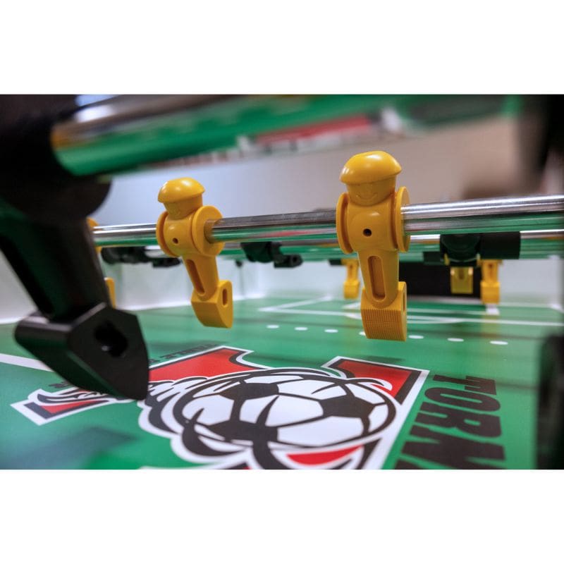 Close-up of a Tornado Elite foosball game with yellow players on a green field.