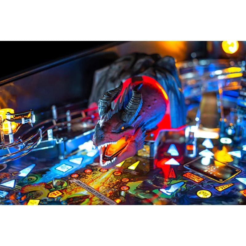 Close-up of dnd pinball machine with a dragon head figure and colorful playfield.