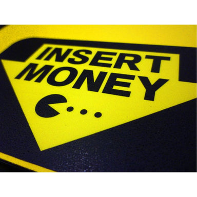 Yellow and black sign with 'Insert Money' text on a textured surface PAC-MAN BATTLE ROYALE DELUXE